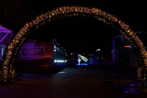 Новогодняя арка - украшена еловыми ветками, игрушками и гирляндами